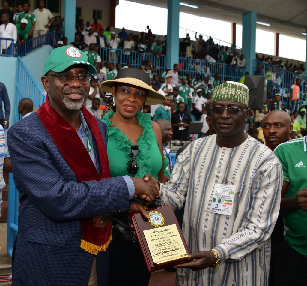 Cross River State Governor, Senator Liyel Imoke (L) receiving a plaque from the President Sports Writers Association of Nigeria (SWAN), Mallam Saidu Abubarka while his wife Mrs. Obioma Liyel Imoke(M) watches shortly after  his investiture as the Patron of the Association at half time during the match between Nigeria and Ethiopia in Calabar on Saturday