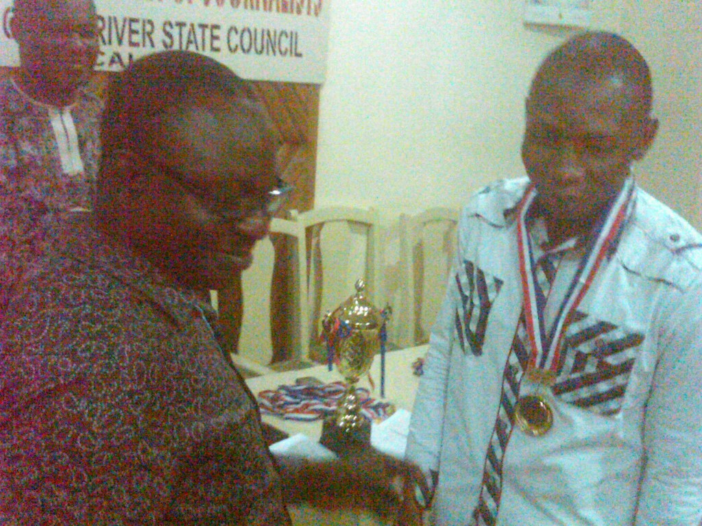 Chairman, Cross River State Council NUJ, Ndoma Akpet handing a prize to George, winner of the table tennis event