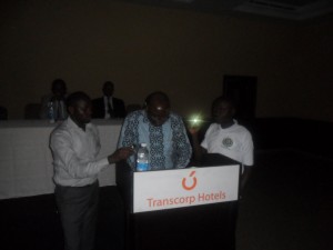 Mr. Kanu Agabi, SAN reading with the aid of a touch light because in the course of speaking electricity supply went off