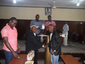 The Acting Senate President exchanging a hand shake with the reinstated Senate President after handing over while others watch