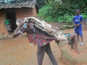 Villager demonsrating how pregnant women are carried to the Ranch during complications