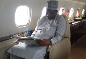 Mr. Jedy Agba reading about Cross River in a local newspaper aboard the chartered jet