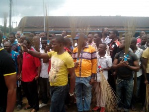 Crowd of supporters carrying brooms (the APC logo) during the ceremony