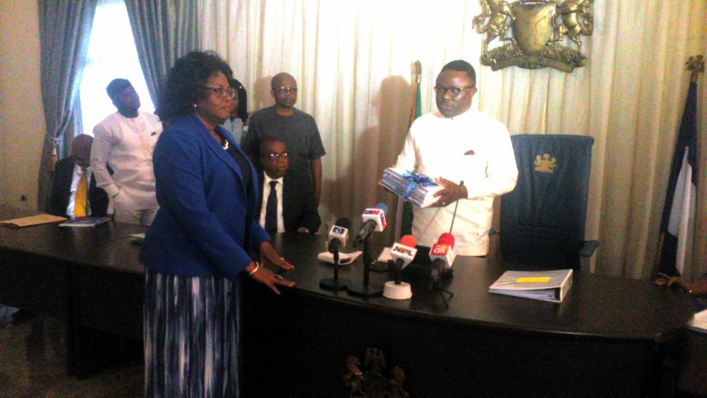 Information Commissioner Rosemary Archibong presenting the book to Governor Ben Ayade while his Deputy Professor Ivara Esu (sitting) looks on