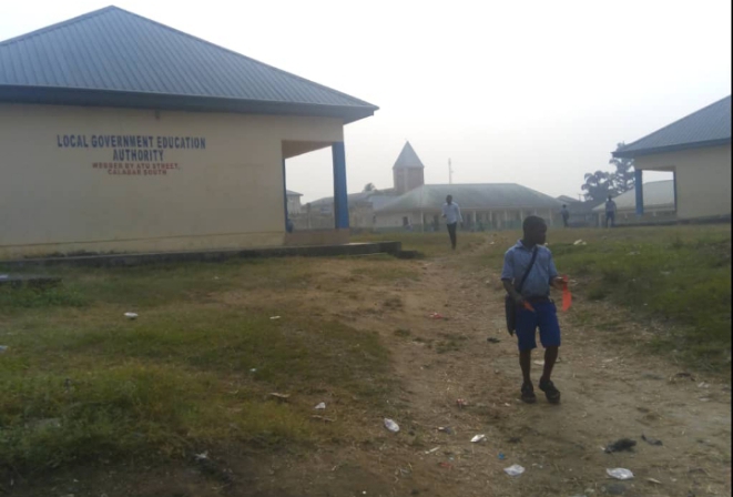 A pupil walks past the Calabar South Local Government Education Authority located within his school premises at Atu street in Calabar after being sent home for not paying illegal levies and fees.