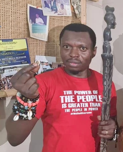 In this cropped image, Journalist and activist, Agba Jalingo hold a cowrie and traditional staff at the office of his lawyer, James Ibor in Calabar. The image is to illustrate his roots. (Credit: CrossRiverWatch/Jonathan Abang Ugbal)