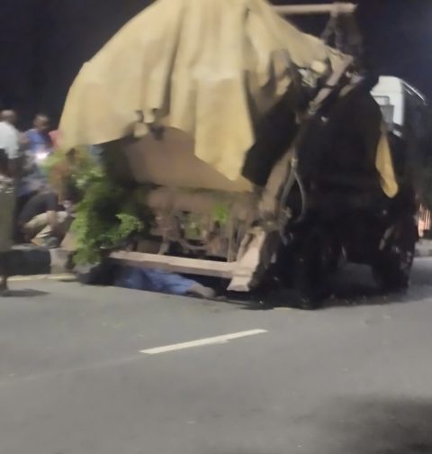 Passers-by and witnesses watch and deliberate the action to take after a waste evacuation truck collapsed on a mechanic along Marian Road in Calabar