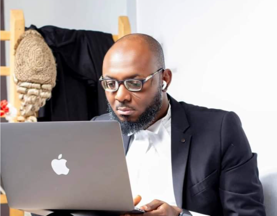 F. Baba Isa examining Section 77 of the Electoral Act on his laptop
